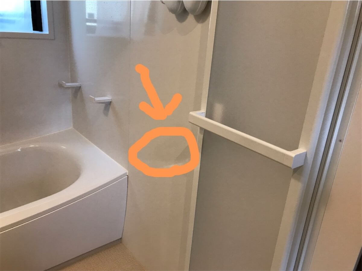 ドアを開けた先に矢印が記入された浴室写真