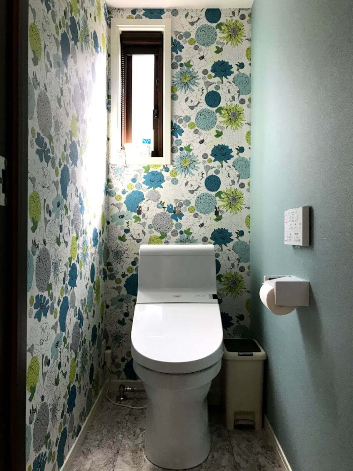 緑色の壁紙と窓のあるトイレ室内